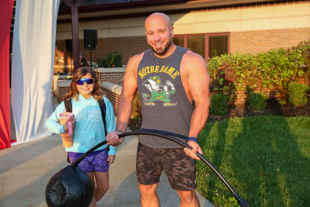 strongman poses with students