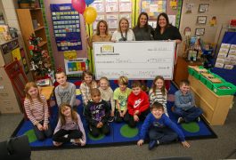 Staff and teachers pose with giant check