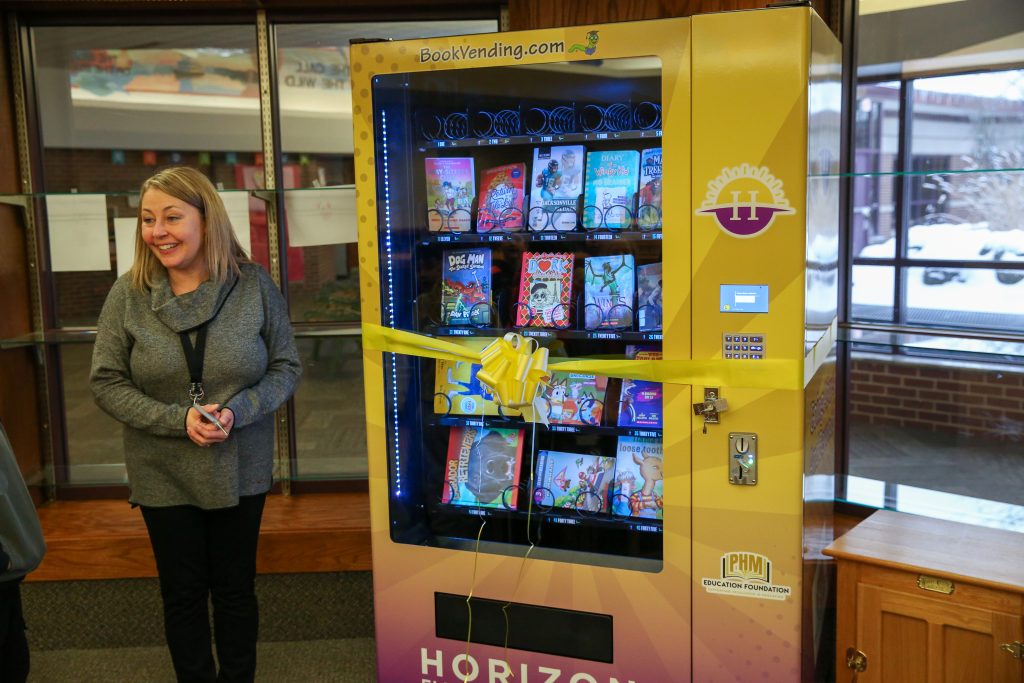 teacher stands with vending machine