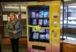 teacher stands with vending machine