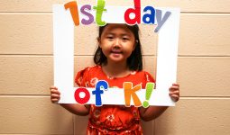 Student holding sign that says 1st day of K!