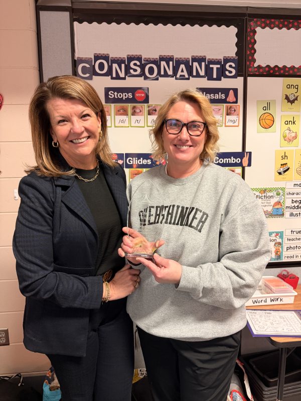 Two women smiling holding an award