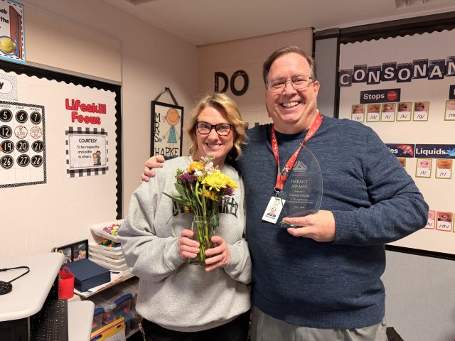 woman smiling holding flowers, man smiling holding award