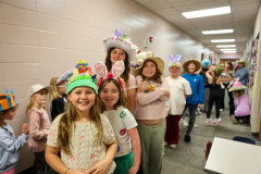 Children in colorful hats they made posing for a picture.