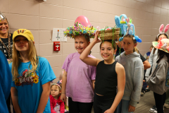 Children in colorful hats they made posing for a picture.