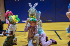 Children in colorful hats they made posing for a picture.
