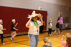 Children in colorful hats they made posing for a picture.