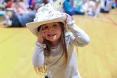 Children in colorful hats they made posing for a picture.